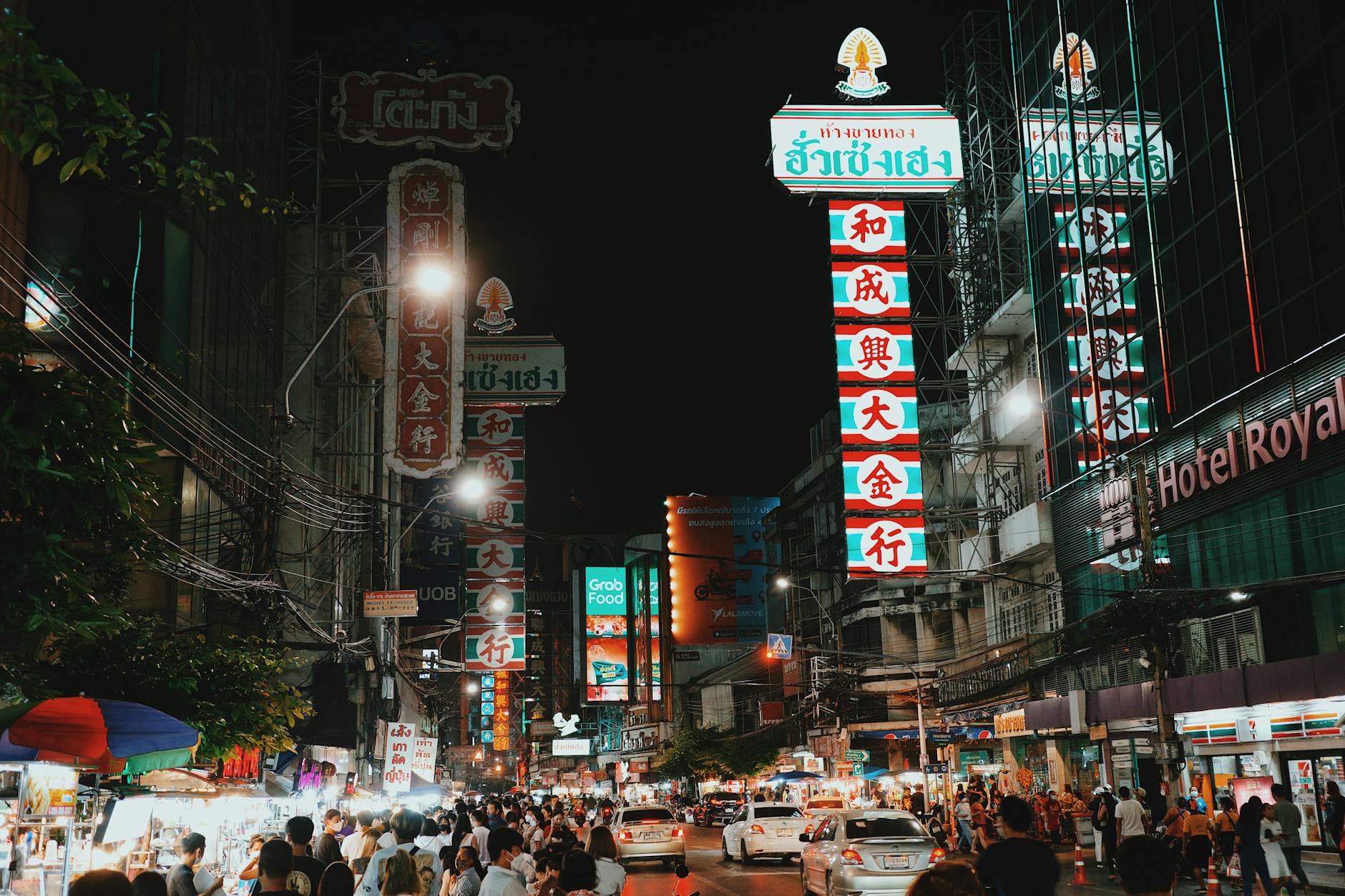 Experience the lively nighttime atmosphere in Bangkok's busy streets filled with neon signs and vibrant crowds.