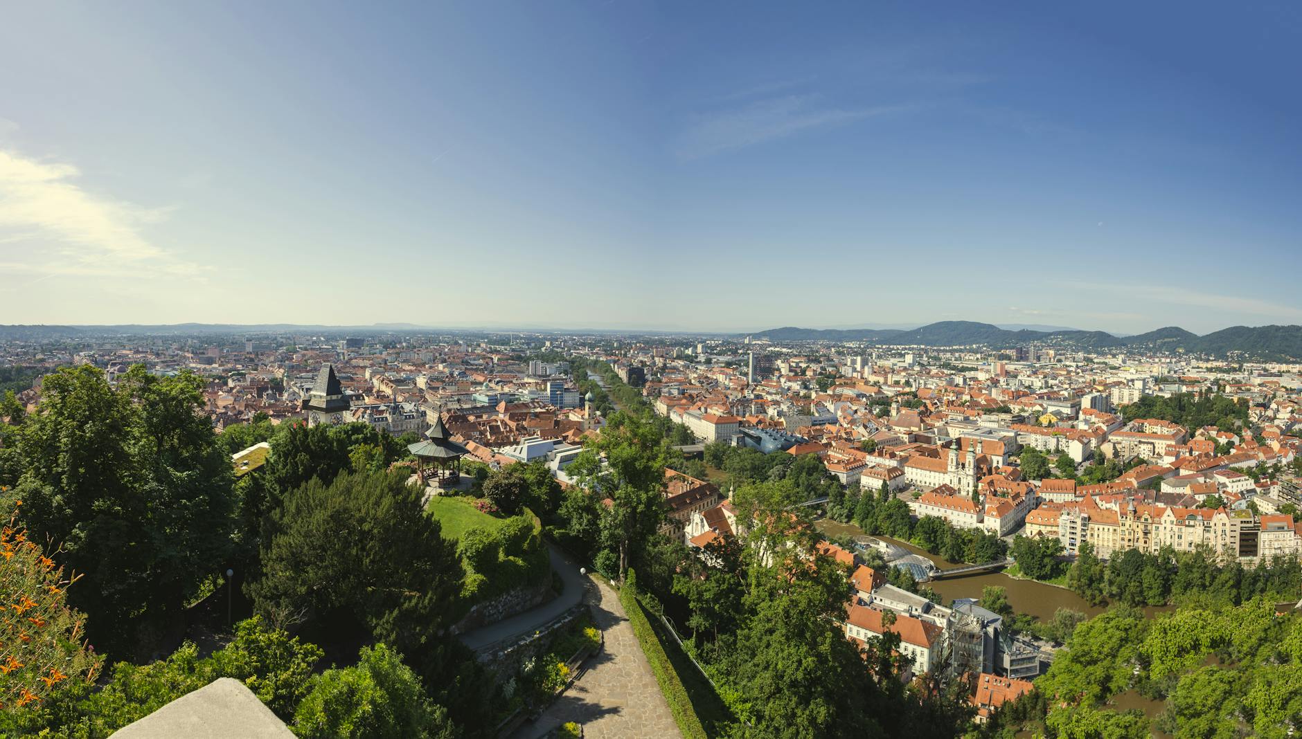 A stunning aerial shot showcasing the sprawling cityscape of Graz, Austria with its mix of greenery and urban architecture.
