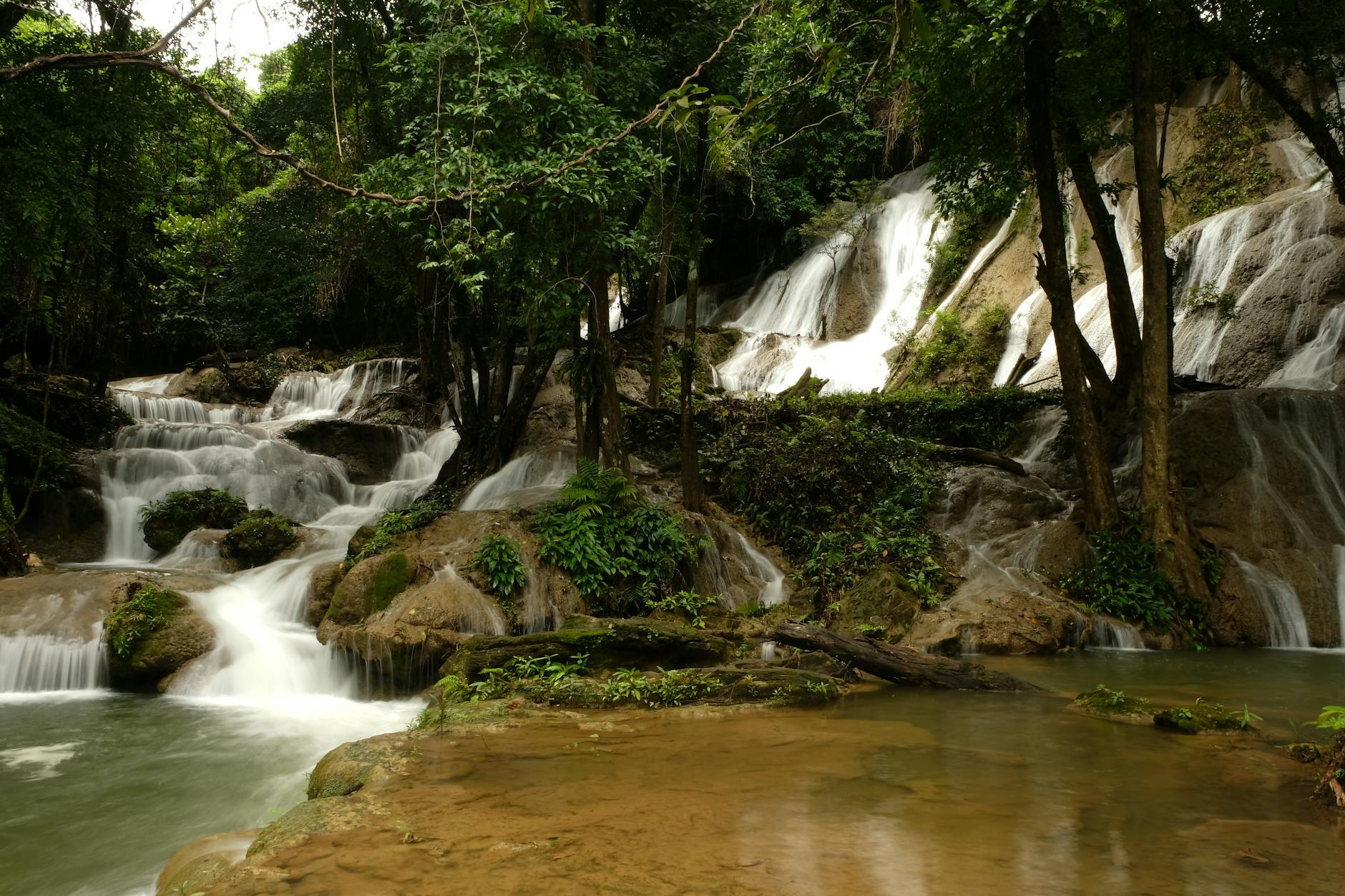 Serene waterfall amidst lush greenery in Kanchanaburi, Thailand, perfect for nature lovers.