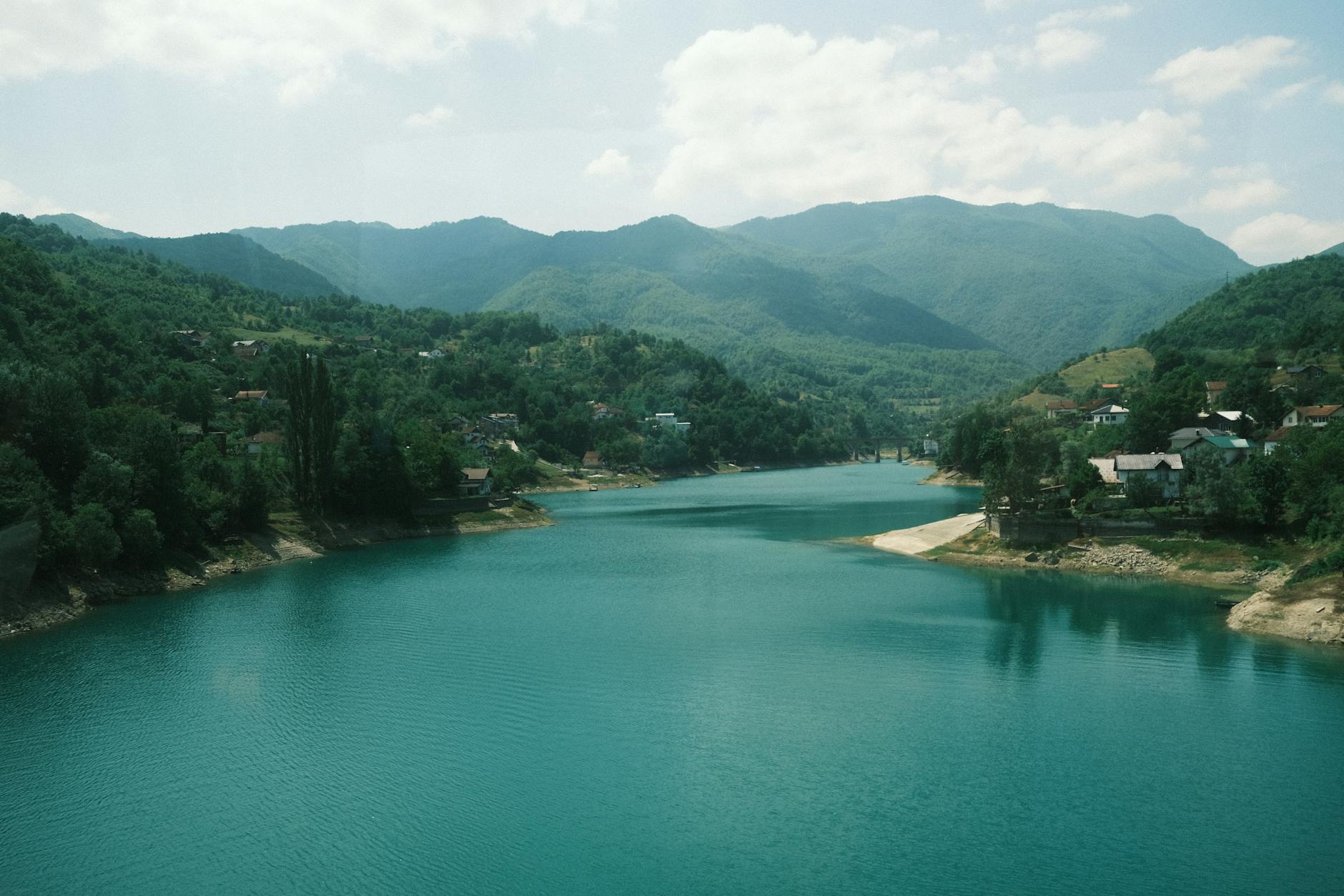 Peaceful river flowing through lush green mountains in Bosnia and Herzegovina.