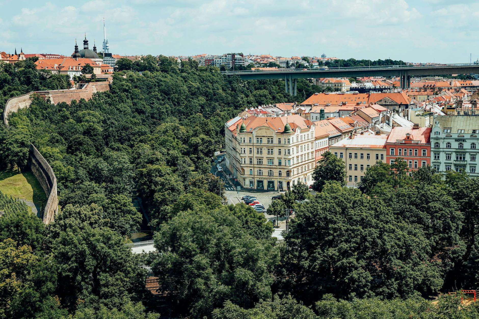Scenic aerial photograph showcasing the Nusle Bridge, lush greenery, and historic architecture of Prague.