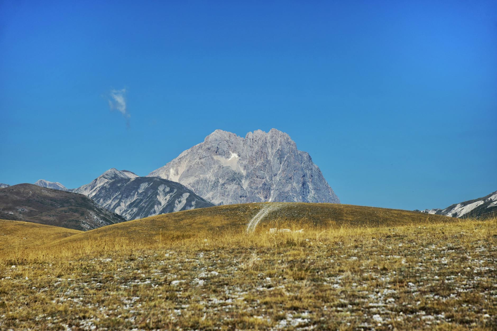 Scenic view of a rocky mountain peak against a vibrant blue sky, perfect for nature enthusiasts.