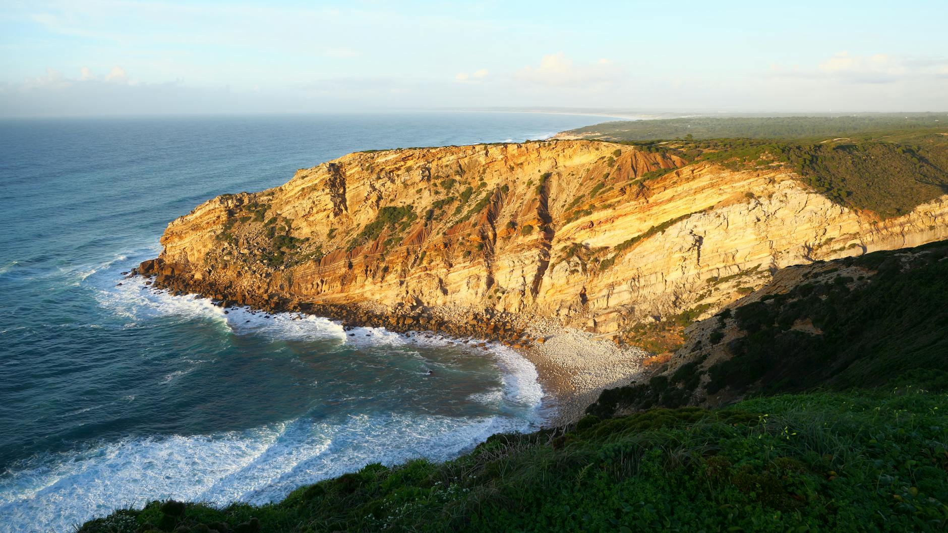 Dramatic coastal cliffs with rocky formations overlooking the blue ocean in Portugal.