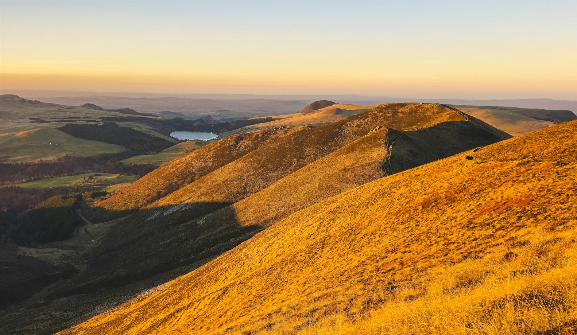 Scenic view of golden hills during sunset in Auvergne-Rhône-Alpes, France.