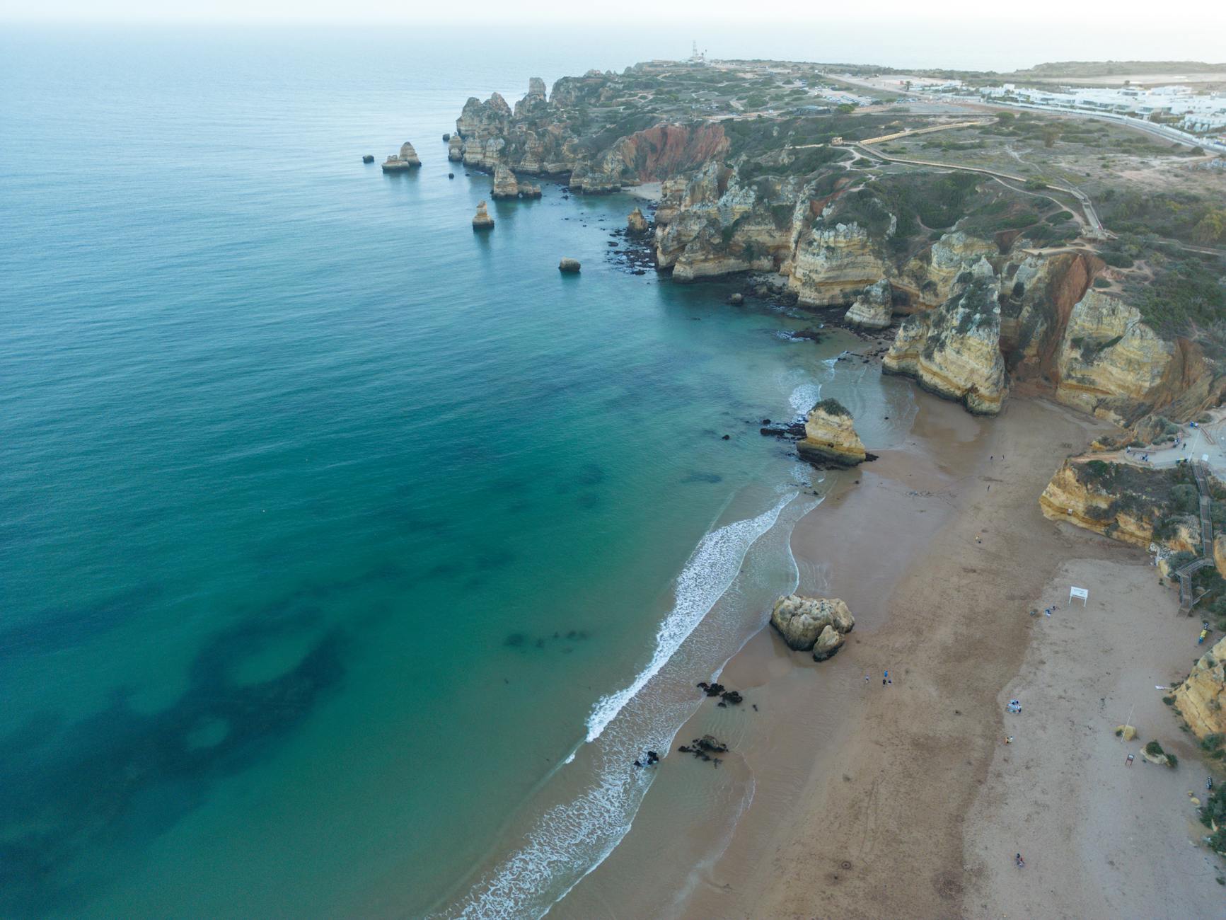 A breathtaking aerial view of the stunning cliffs and sandy beach in Lagos, Portugal.