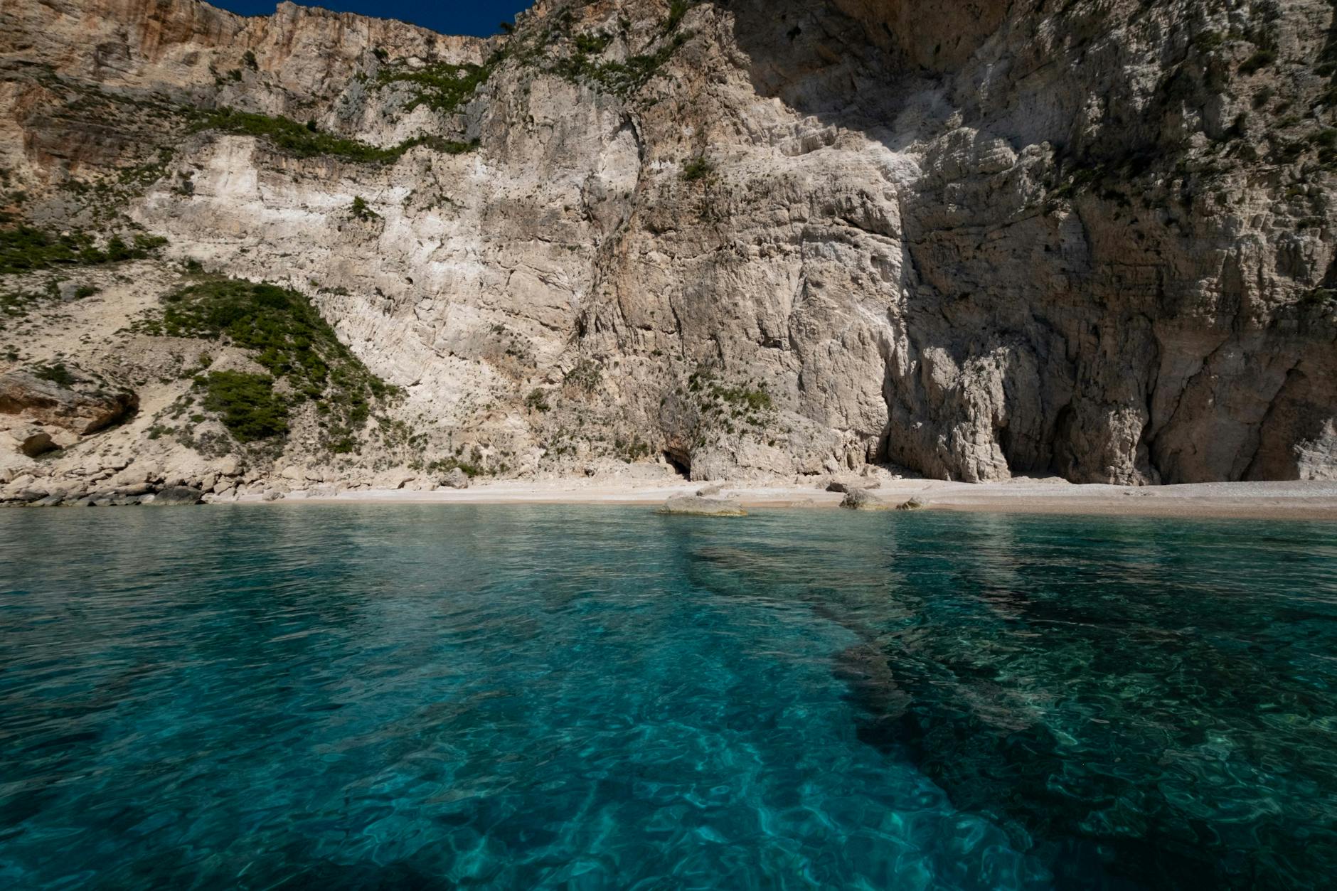 Stunning beach with turquoise waters and majestic rocky cliffs, captured on a clear day.