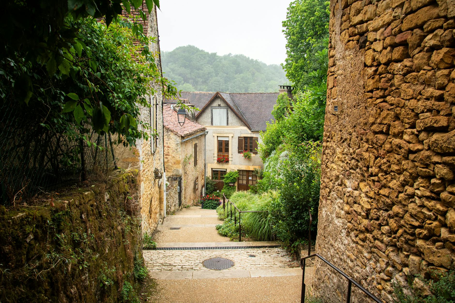 Explore a quaint village alleyway in Nouvelle-Aquitaine, France, surrounded by charming stone architecture.
