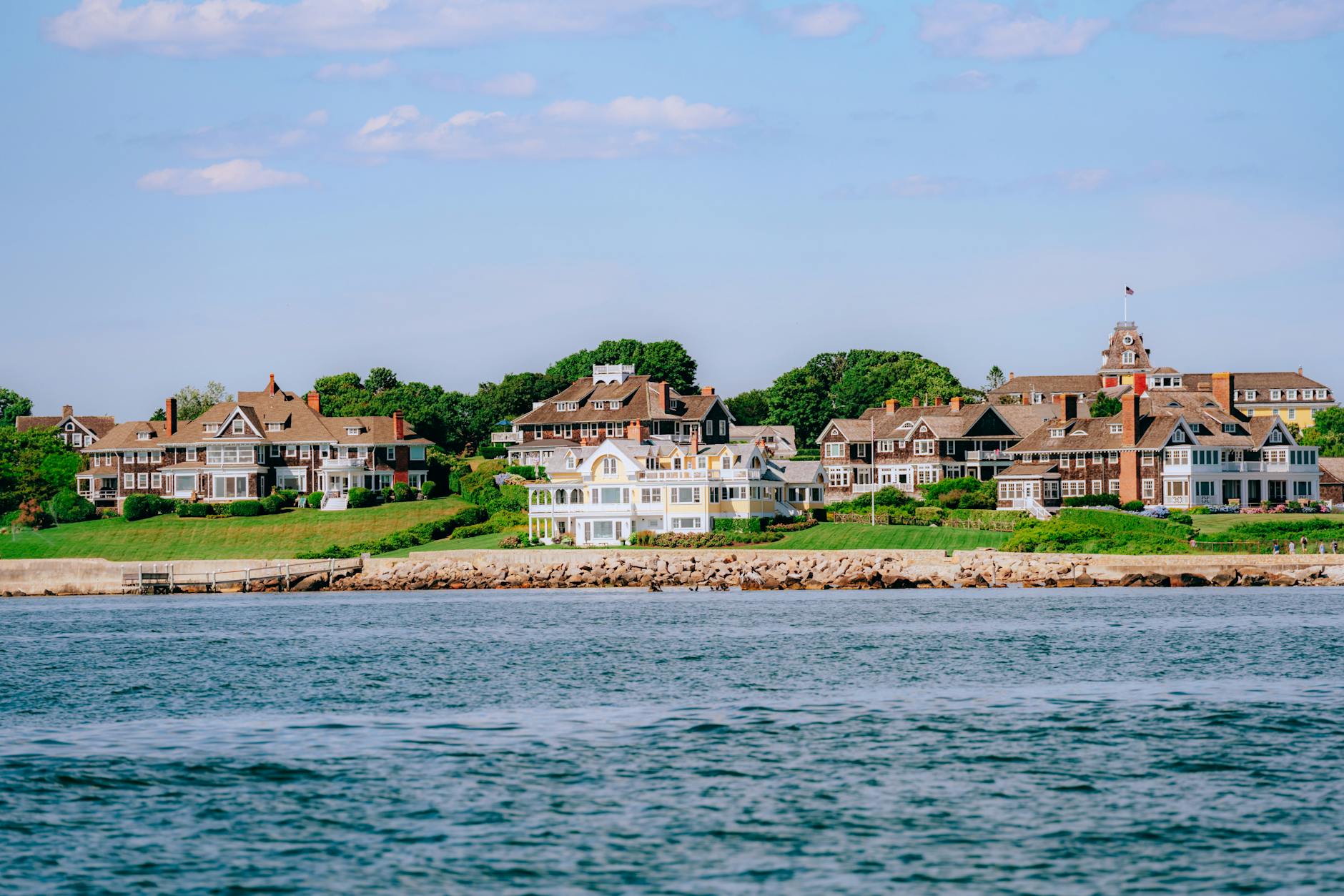 Scenic landscape of coastal luxury homes with lush greenery and tranquil waters.