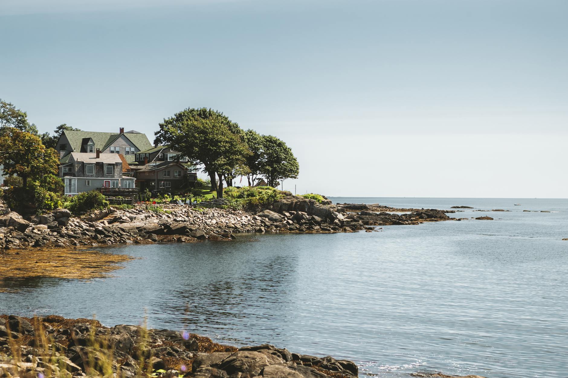 Charming coastal houses by rocky shore in Portland, Maine.